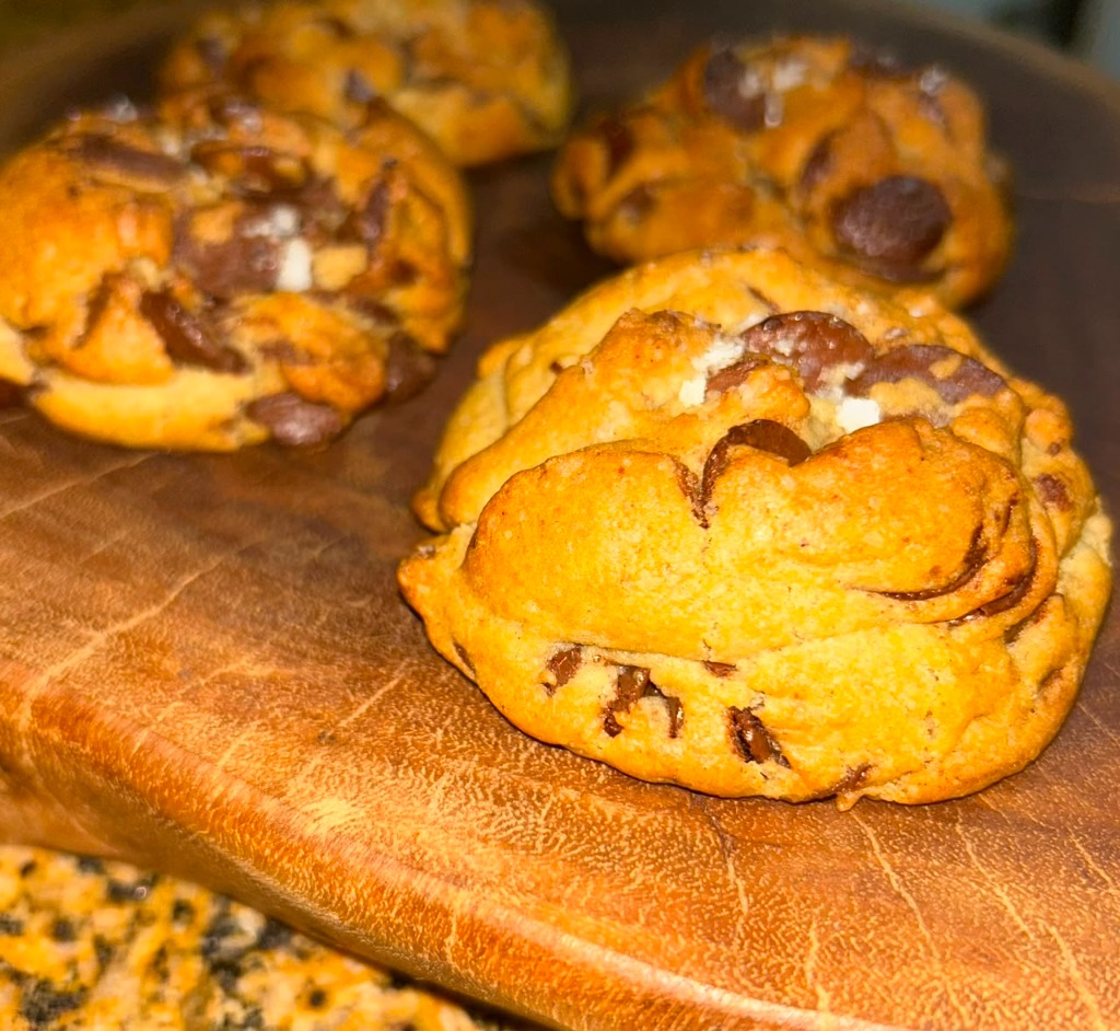 Cookies artesanais com gotas de chocolate e flor de sal sobre tábua de madeira
